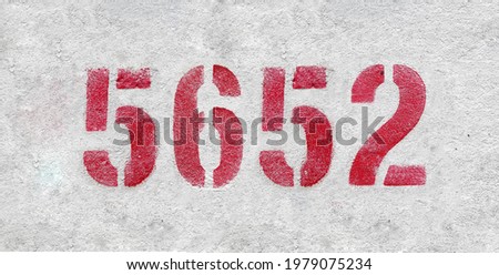 Red Number 5652 on the white wall. Spray paint.