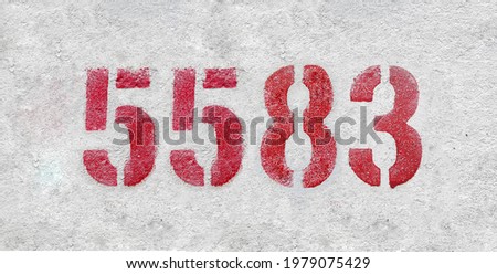 Red Number 5583 on the white wall. Spray paint.