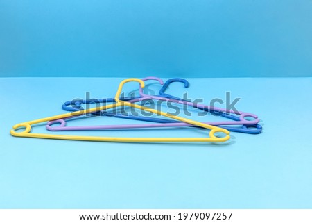 three plastic clothes hangers on a blue background
