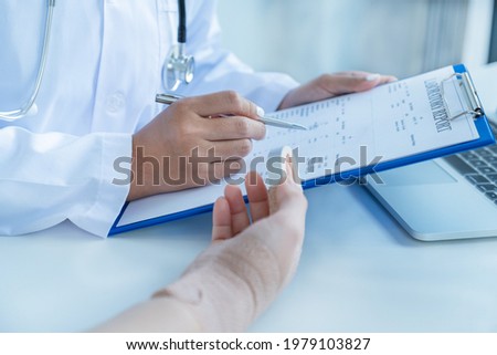 Doctors hand holding pen and report health examination results, recommend medication to patients in arm accident.