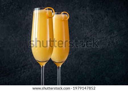 Two glasses of Buck's Fizz cocktail on black background Royalty-Free Stock Photo #1979147852