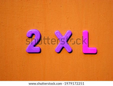 2 XL colored plastic letters on a brown painted background