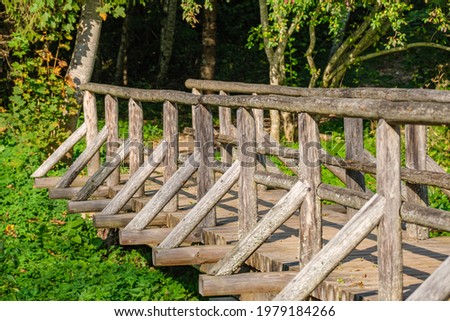 tourism pathway in the summer green park with gravel, wooden rails and trees. relaxation in nature