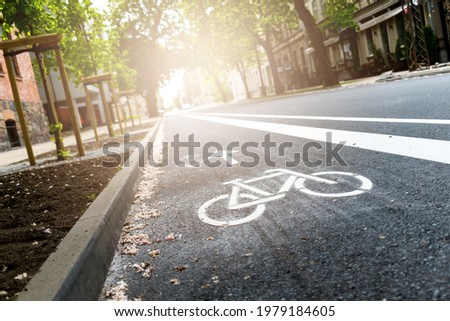 Freshly build bicycle lane in the city,Bike path. Sign white paint on the pavement. Summer. bicycle traffic sign painted on the asphalt
