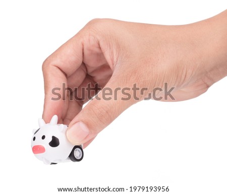 hand with toy cow wind up Isolated on a white background.