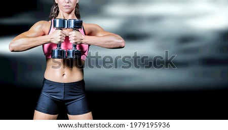 Composition of muscular woman exercising with dumbbells over black blur. sport, fitness and active lifestyle concept digitally generated image.