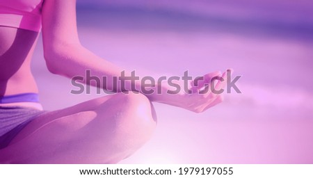 Composition of fit woman meditating on the beach over light blur. sport, fitness and active lifestyle concept digitally generated image.