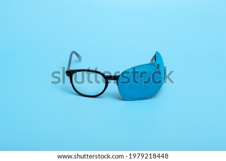 Children's glasses with occluder on a colored background. Lazy eye. Amblyopia Royalty-Free Stock Photo #1979218448