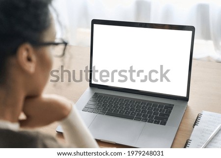 Over shoulder view of female student business woman looking at empty blank mockup, white laptop screen display for advertising, having virtual meeting, remote work, search online, watching webinar.