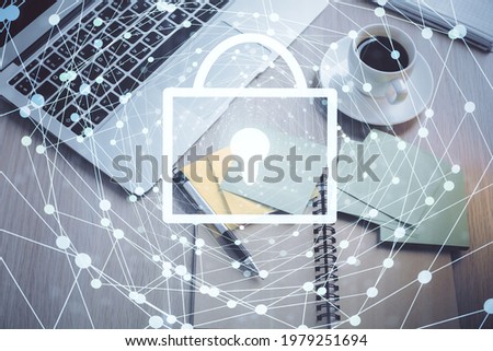 Double exposure of lock hologram drawing over study table background with computer. Concept of data security. Top view.