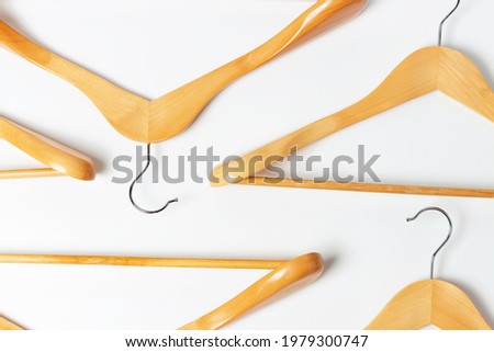 Pattern of wooden hangers on white background close-up top view.