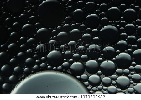 abstract macro background of oil circles floating over the water surface. Macro close-up view of bubbles on water.