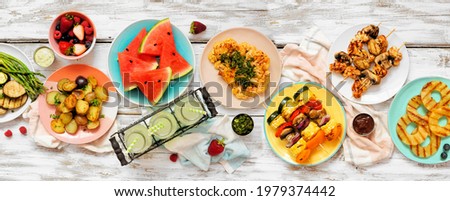 Vegan summer bbq or picnic table scene.Above view on a white wood banner background. Fruit, grilled vegetables, skewers, cauliflower steak and lemonade. Meat substitute concept.