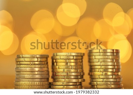 Money and finance.Coins columns in gold glitter on a golden background.Money growth.Money symbol. Wealth and success concept.Investments and savings