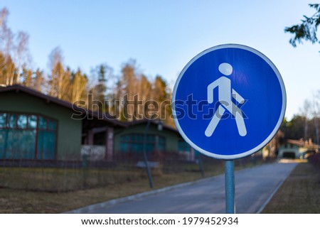 Road sign "Pedestrian zone". The sign is installed before the beginning of the alley in a country cottage village