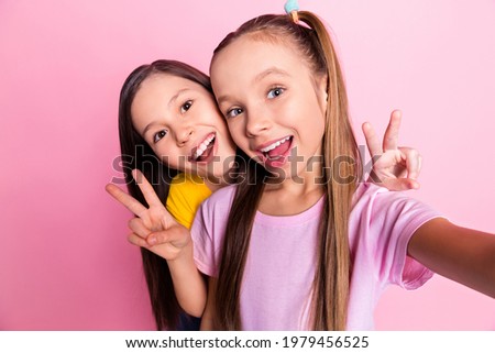 Photo of optimistic brunette blond girls do selfie show v-sign wear yellow pink t-shirt isolated on pink color background