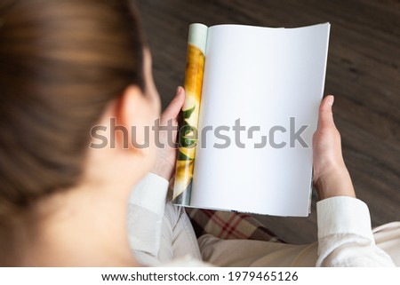 top view of a woman reading an open book or magazine. empty page. mock up Royalty-Free Stock Photo #1979465126