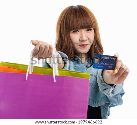 Brown hair Asian woman she stretched out both hands holding shopping bags and mock up credit card toward camera, studio shot on white background.