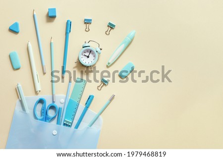 Back to school creative background. Open envelope and school supplies, pencils, pens, rulers, blue and yellow pastel colored.