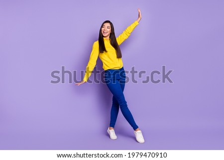 Full length photo of charming attractive young woman dance raise hands look empty space isolated on violet color background