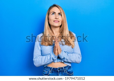 Young caucasian woman wearing casual clothes begging and praying with hands together with hope expression on face very emotional and worried. begging. 