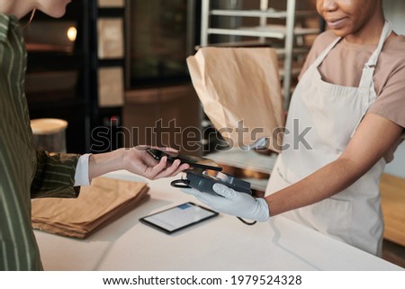 Customer paying online for fresh bread in bakery shop
