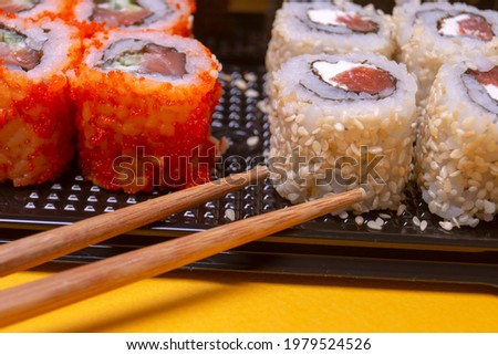 small portion of rolls with fish on an orange background