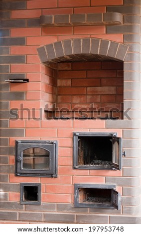 brick facade closeup of big house stove with metal doors and decorated cooker