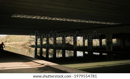 Manchester (UK) Under a motorway bridge over the Bridgewater canal with cyclist on tow path.