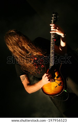 Guitarist with long hair on stage.