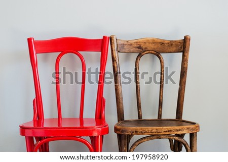 Pair of Red and Brown Chairs on a Grey Wall Royalty-Free Stock Photo #197958920