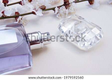 Light beauty desktop background with Bottle of female perfume and blossom branch cherry.