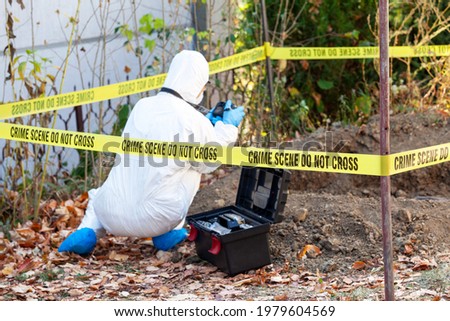 Crime scene investigation. Forensic science specialist photographing human remains. Royalty-Free Stock Photo #1979604569