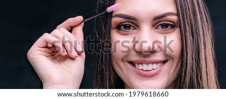 Smiling brunette with brush. Eyebrow master. Face of beautiful girl close up in studio.Banner