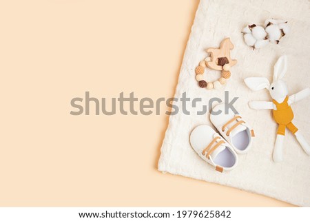 Gender neutral baby shoes and accessories over beige background.