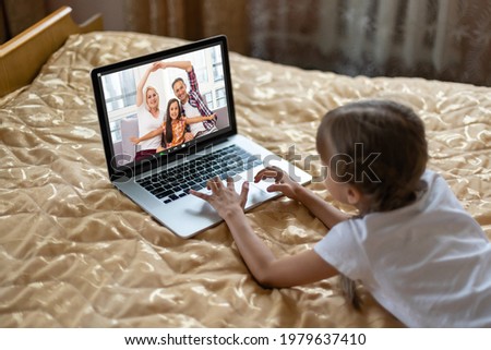 couple waving while having a videocall in santa hats on laptop at home. social distancing during christmas festivity quarantine lockdown concept.