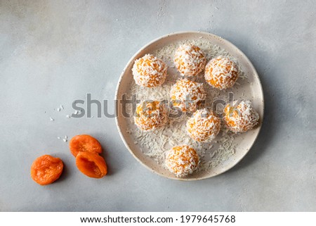 vegan energy balls with dried apricots and coconut in ceramic plate. vegan alternative food. Gray background. top view. copy space Royalty-Free Stock Photo #1979645768