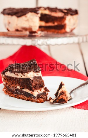 Dark chocolate cake with Coffee slice with chocolate buttercream frosting on a white plate.Selective focus.