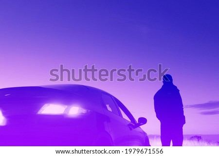 A man looking at the sunset next to a car with the headlights on. On a summers evening. With a neon digital, vaporwave edit.
