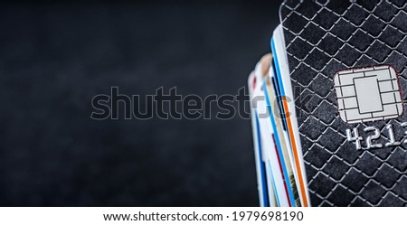 Credit cards stack on dark background with copy space