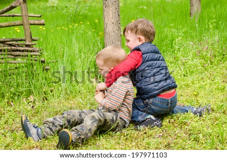 Two Boys Playfully Wrestling in the Grass.
