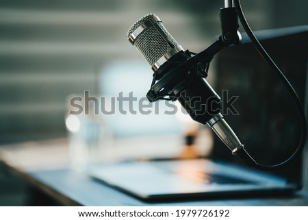 Home studio podcast interior. Microphone, laptop and on air lamp on the table Royalty-Free Stock Photo #1979726192