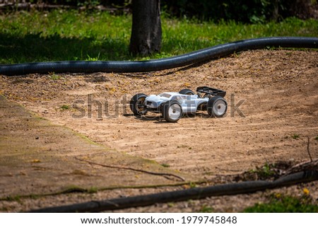 White Radio Controlled (RC) Offroad Truggy on an outdoor track training during sunny day Royalty-Free Stock Photo #1979745848