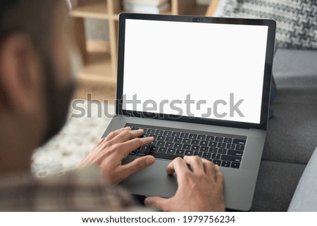 Latin indian adult student typing working remotely online on training educational webinar chatting at home office using laptop computer looking at mockup empty screen. Over shoulder view. Royalty-Free Stock Photo #1979756234