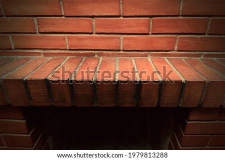 Empty red brick mantel. Backdrop of a brick fireplace wall in a vacant setting