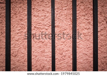 cast iron fence bars close-up against the background of a plastered wall