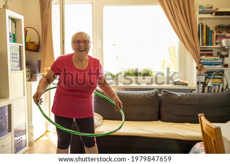Older woman hula hooping at home

