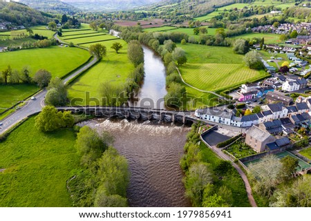 Aerial view of an old bridge across a fast flowing river (River Usk, Crickhowell, Wales) Royalty-Free Stock Photo #1979856941