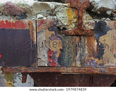 rusting painted metal and weathered wood with chipped layers of paint and stone crumbling and and aging naturally together beautiful decay grunge background texture