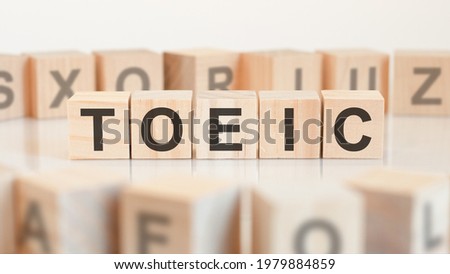 Toy wood blocks with letters TOEIC on a table with light background, selective focus. TOEIC - short for Test of English for International Communication